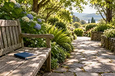A quiet garden bench beside a shaded path with a blue notebook
